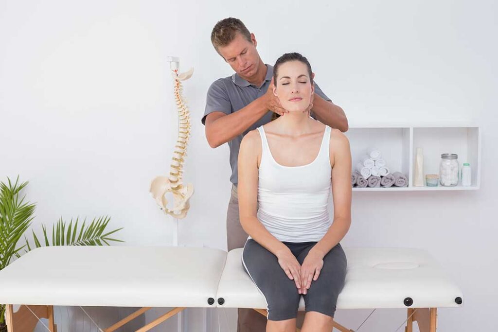 Adult practicing gentle balance exercises beside a sturdy chair in a bright home.